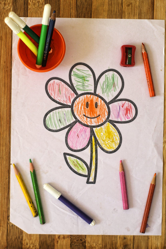 a child's drawing of a flower with crayons
