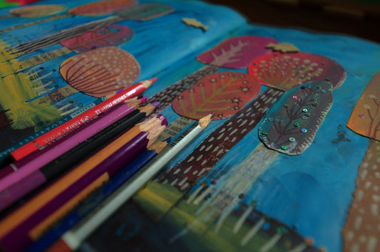 Colored pencils on a colorful ocean-themed artwork.