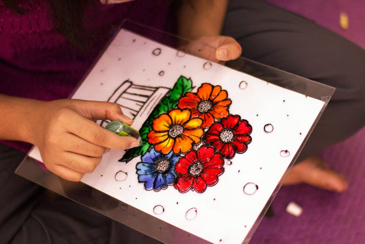 Person painting colorful flowers on a white background